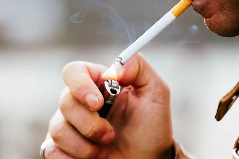 Điếu thuốc cháy sáng trong bóng đêm, ánh sáng đỏ làm nổi bật. Điếu thuốc cháy sáng trong bóng đêm, ánh sáng đỏ làm nổi bật.