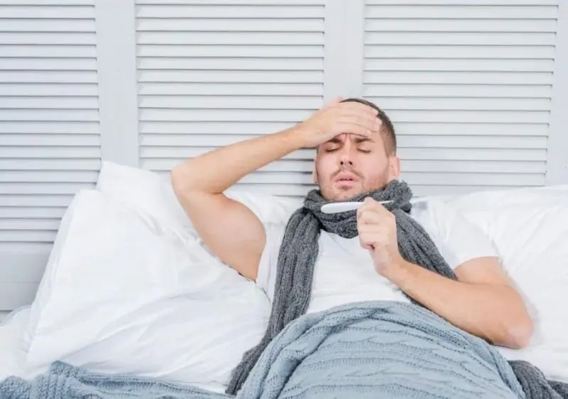 Hình ảnh người lớn sốt được đắp chăn để giữ ấm Hình ảnh người lớn sốt được đắp chăn để giữ ấm