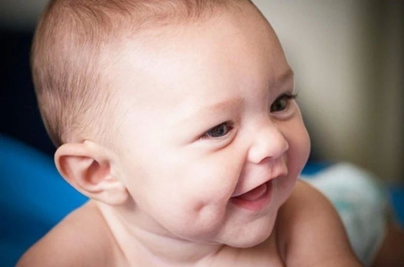 Hình ảnh em bé má lúm cười nhẹ nhàng cực dễ thương