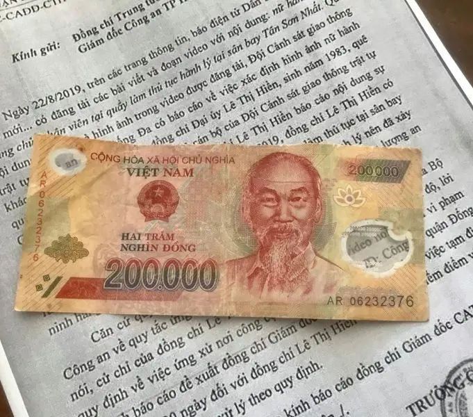 Xấp tiền 200K đặt trên bàn làm việc Xấp tiền 200K đặt trên bàn làm việc