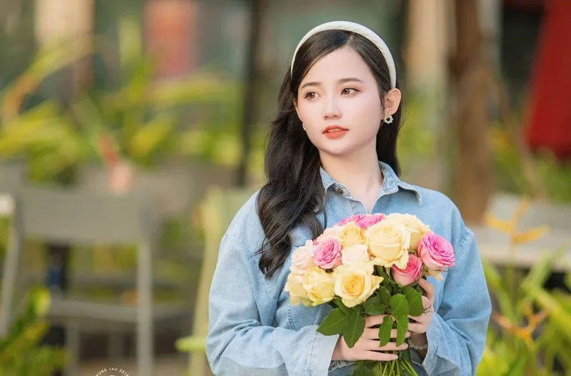 Cô gái ôm bó hoa tươi rạng rỡ giữa khung cảnh thiên nhiên Cô gái ôm bó hoa tươi rạng rỡ giữa khung cảnh thiên nhiên