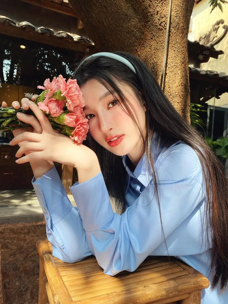 Cô gái với nụ cười ngọt ngào ôm bó hoa hồng rực rỡ Cô gái với nụ cười ngọt ngào ôm bó hoa hồng rực rỡ