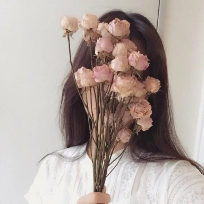 Cô gái ôm bó hoa với ánh nhìn xa xăm đầy mơ mộng Cô gái ôm bó hoa với ánh nhìn xa xăm đầy mơ mộng