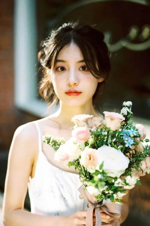 Cô gái ôm bó hoa giữa đồi cỏ xanh, mang vẻ đẹp trong trẻo Cô gái ôm bó hoa giữa đồi cỏ xanh, mang vẻ đẹp trong trẻo