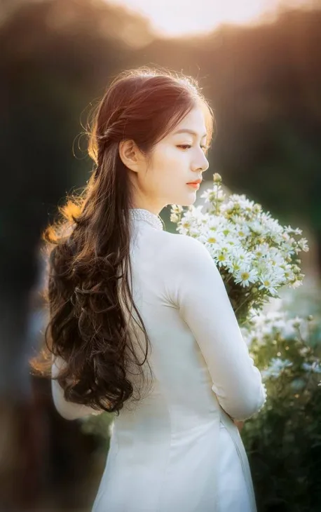 Ảnh cô gái ôm bó hoa và mỉm cười dưới ánh hoàng hôn Ảnh cô gái ôm bó hoa và mỉm cười dưới ánh hoàng hôn