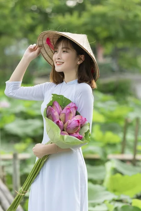 Hình ảnh cô gái ôm bó hoa sen trắng, tinh khôi và bình yên Hình ảnh cô gái ôm bó hoa sen trắng, tinh khôi và bình yên