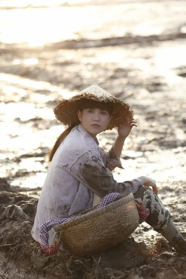 Cô gái quê giản dị với tà áo bà ba bên bờ ao Cô gái quê giản dị với tà áo bà ba bên bờ ao