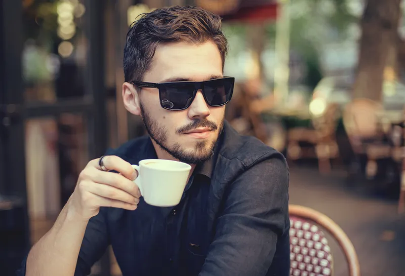 Trai đẹp ngồi uống cafe với khung cảnh thành phố Trai đẹp ngồi uống cafe với khung cảnh thành phố