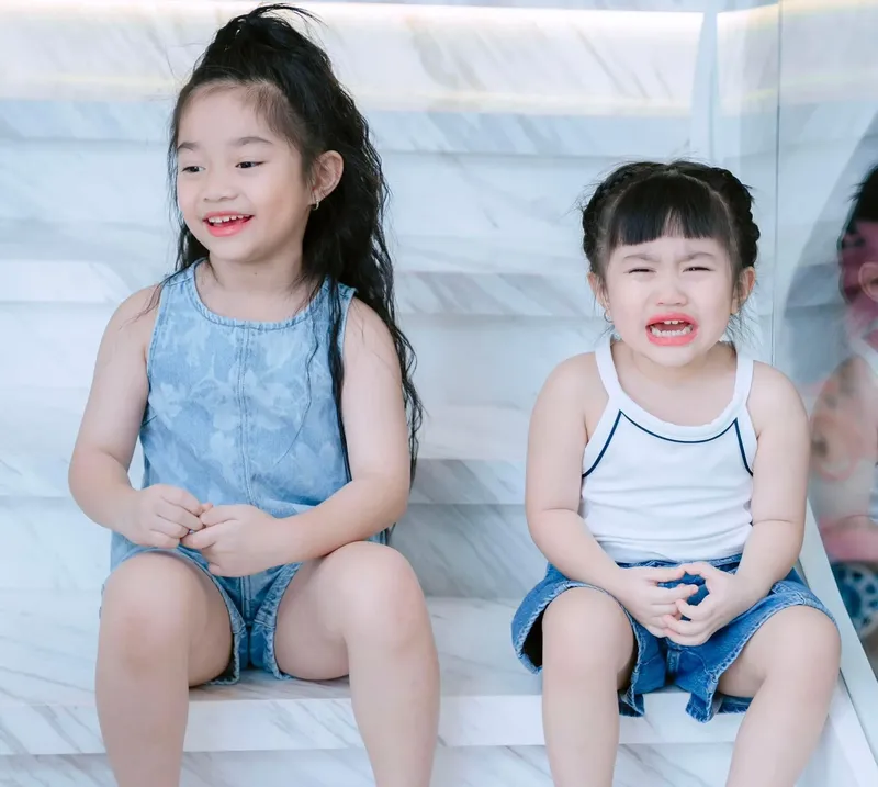 Dáng ngồi đáng yêu của em bé gái trên ghế nhỏ